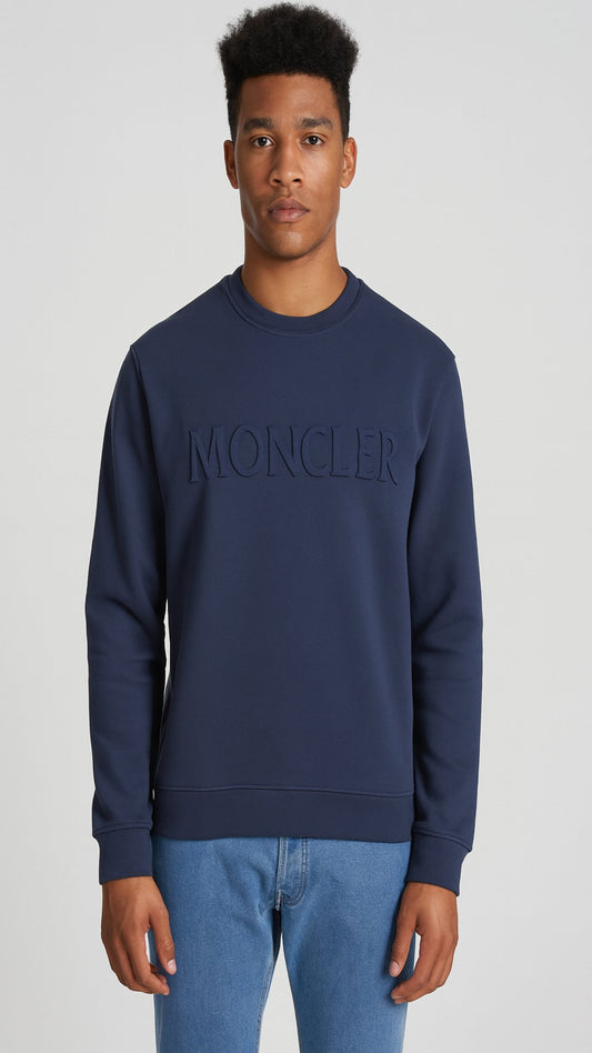 Person wearing a navy Moncler sweatshirt on a light gray background
