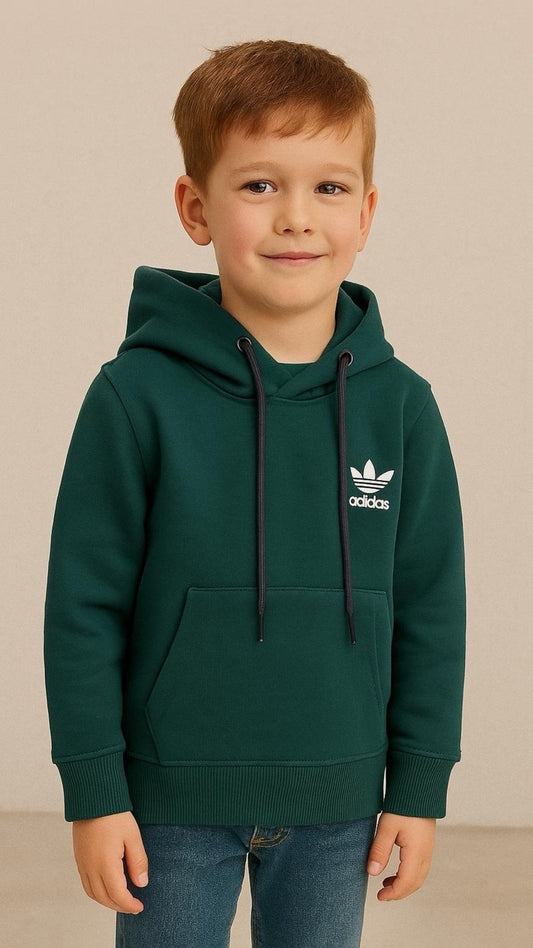Young boy wearing a green Adidas hoodie against a beige background