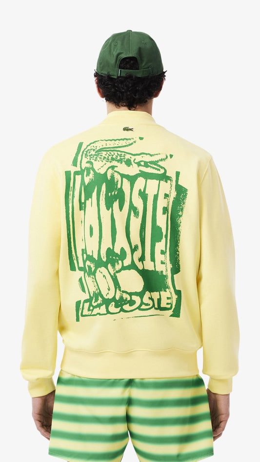 Person wearing a yellow sweatshirt with green text and graphics, green cap, and green and white striped shorts on a white background.