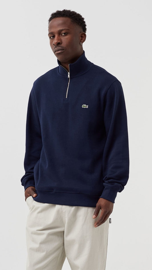 Man wearing a navy blue sweatshirt with a brand logo on a white background