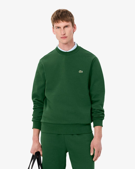 Man wearing a green sweatshirt with a brand logo on a white background