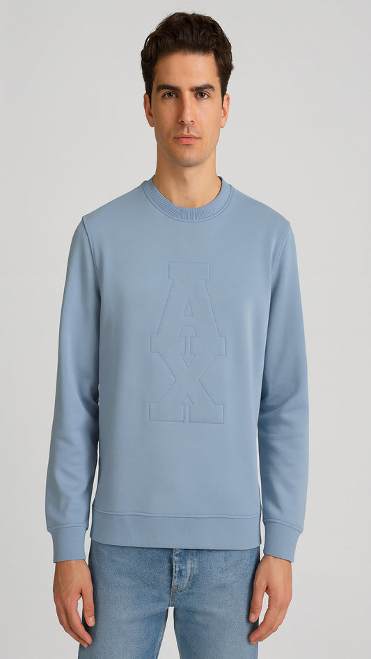 Man wearing a light blue sweatshirt and jeans on a gray background