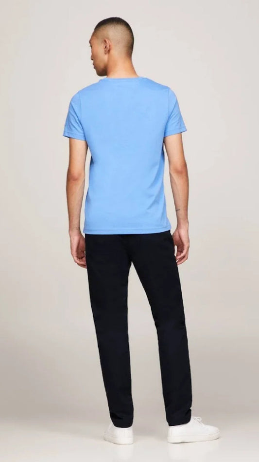 Person wearing a blue t-shirt and black pants on a plain background