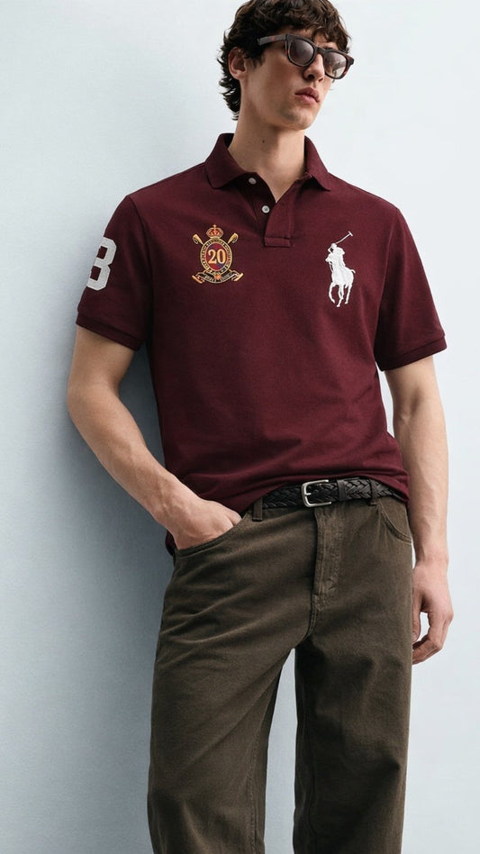 Man wearing a burgundy Polo Ralph Lauren shirt with a logo against a light gray background