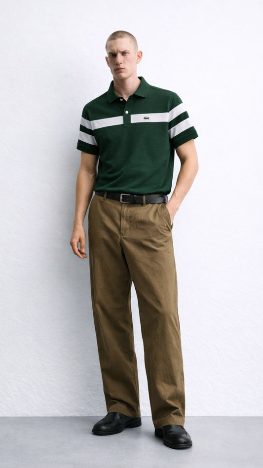 Man wearing a green polo shirt with white stripes and brown pants on a white background