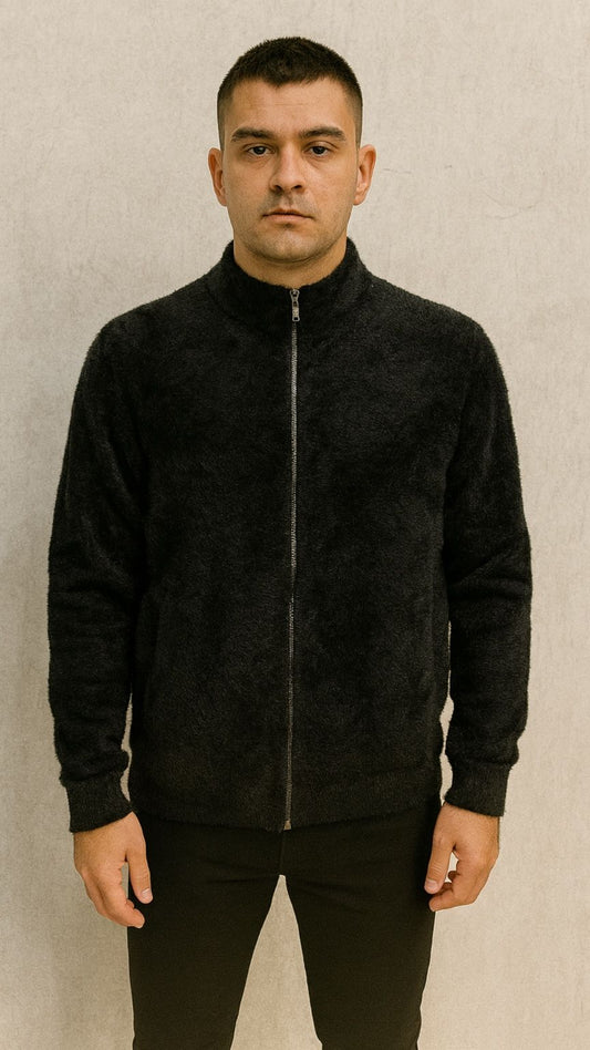 Man wearing a black zip-up jacket against a beige background