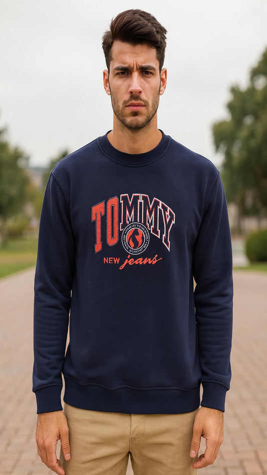 Man wearing a navy blue Tommy Hilfiger sweatshirt outdoors.