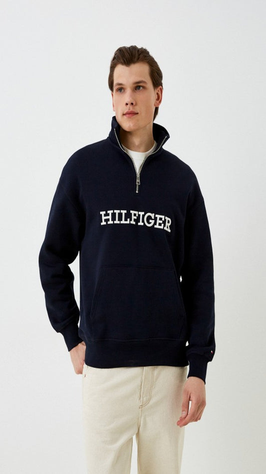 Man wearing a navy Tommy Hilfiger sweatshirt on a white background