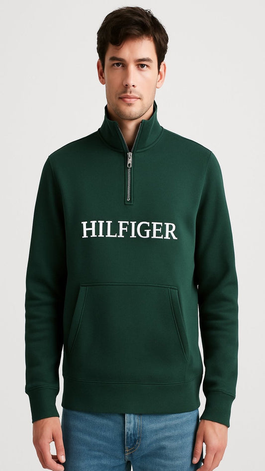 Man wearing a green Tommy Hilfiger sweatshirt on a light gray background
