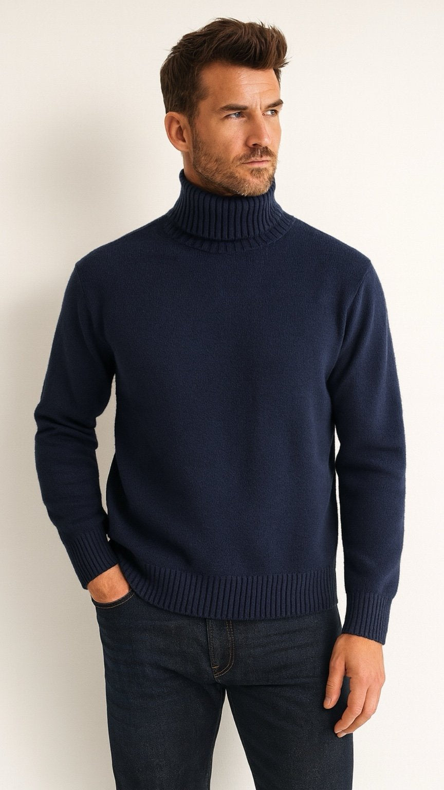Man wearing a navy turtleneck sweater against a white background