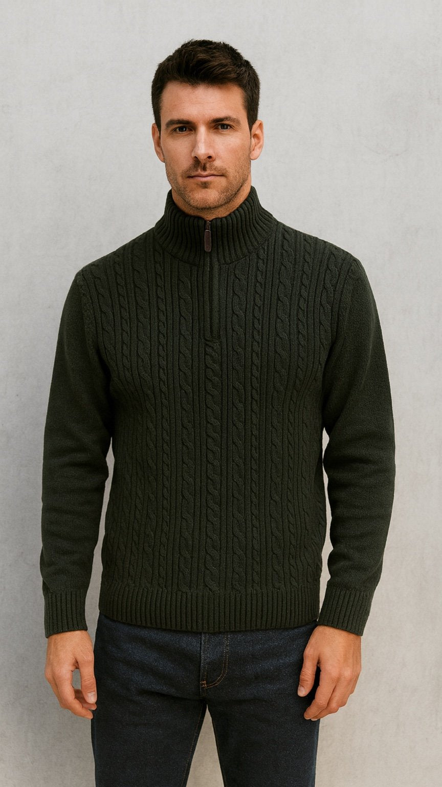 Man wearing a dark green cable knit sweater against a plain background