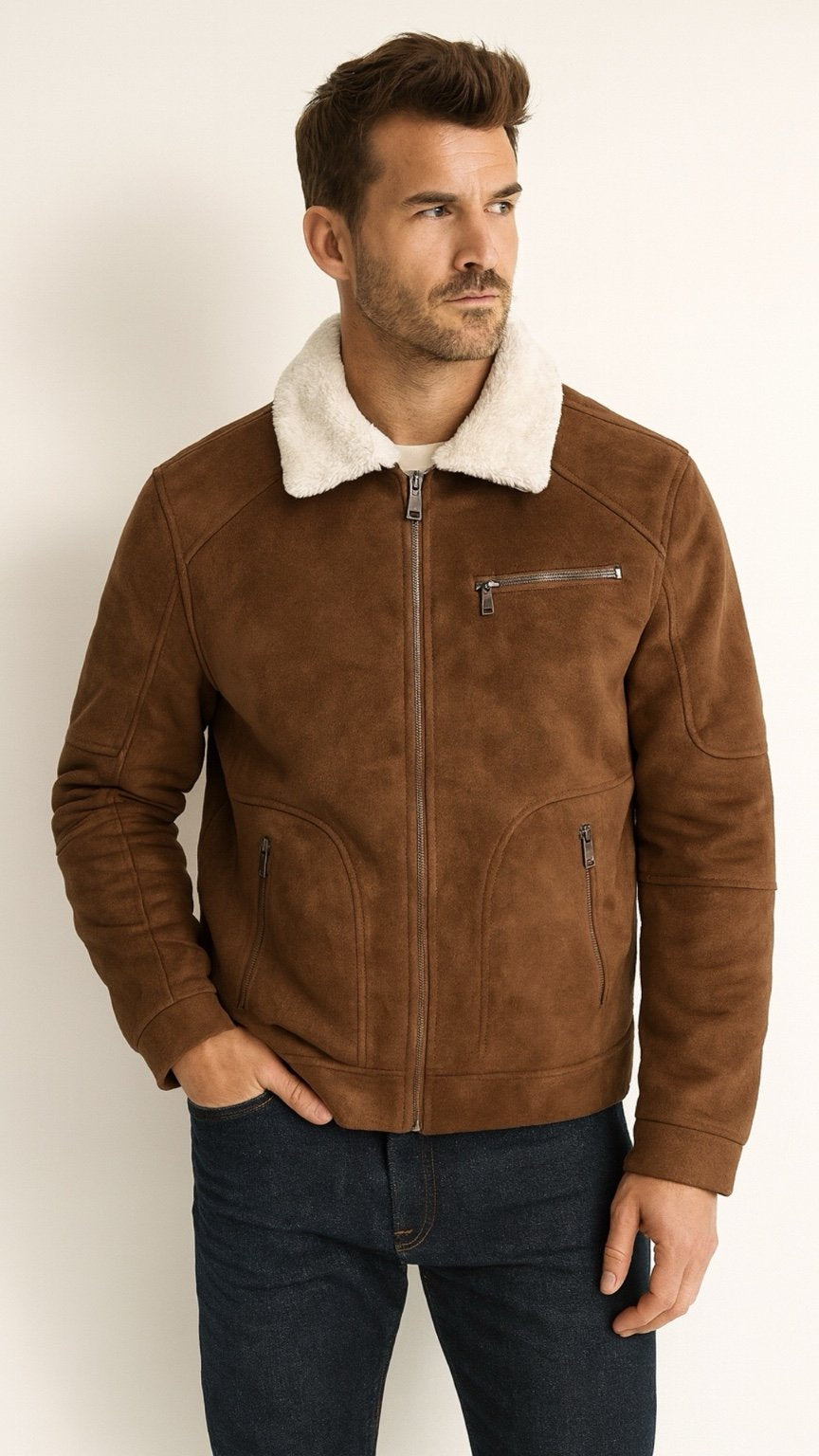 Man wearing a brown leather jacket with white fur lining on a plain background