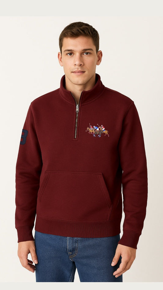 Man wearing a burgundy half-zip sweatshirt with a colorful emblem on a white background