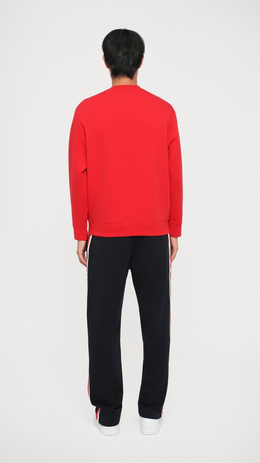 Person wearing a red sweatshirt and black pants on a white background