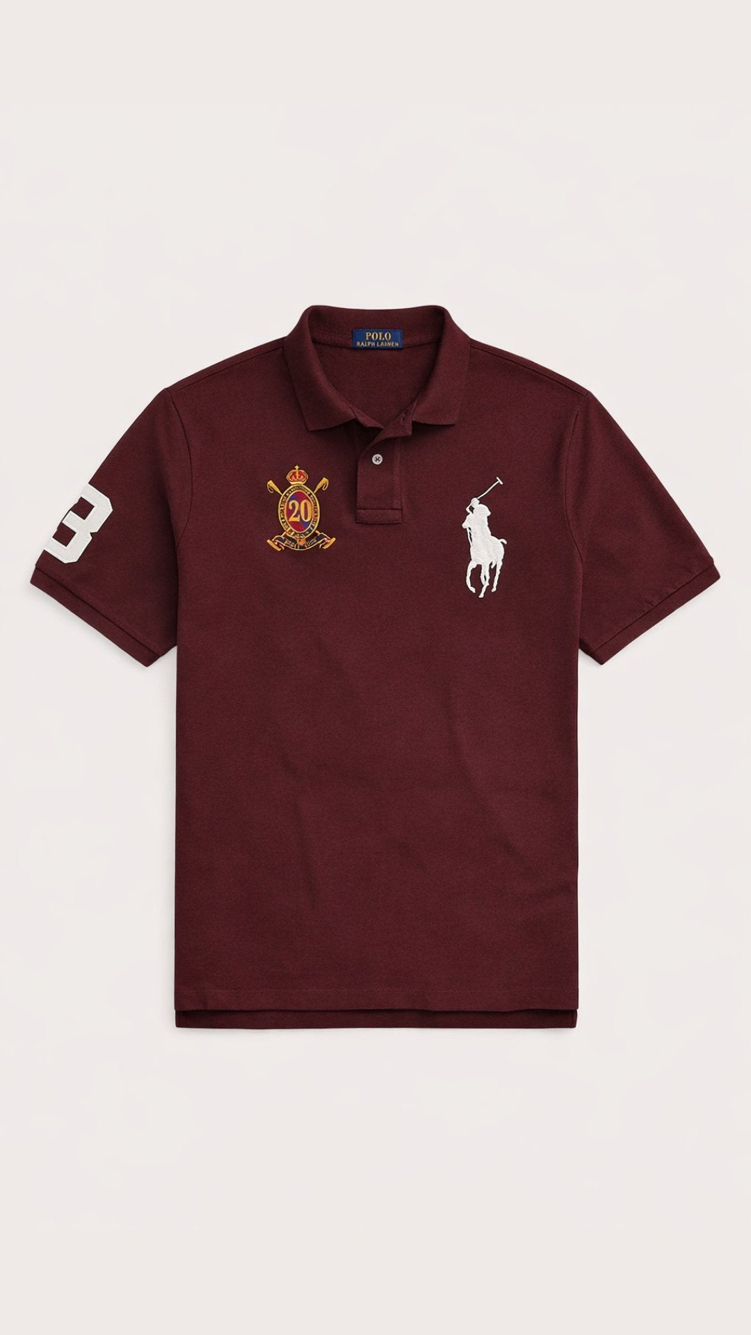 Maroon polo shirt with logos on a beige background