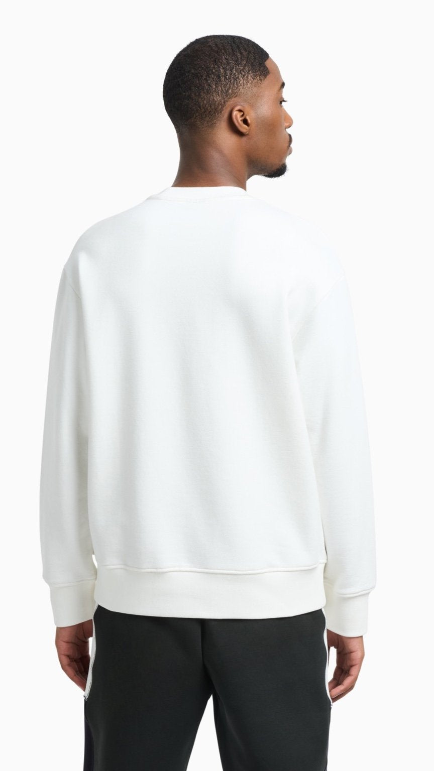 Man wearing a white sweatshirt and black pants on a white background