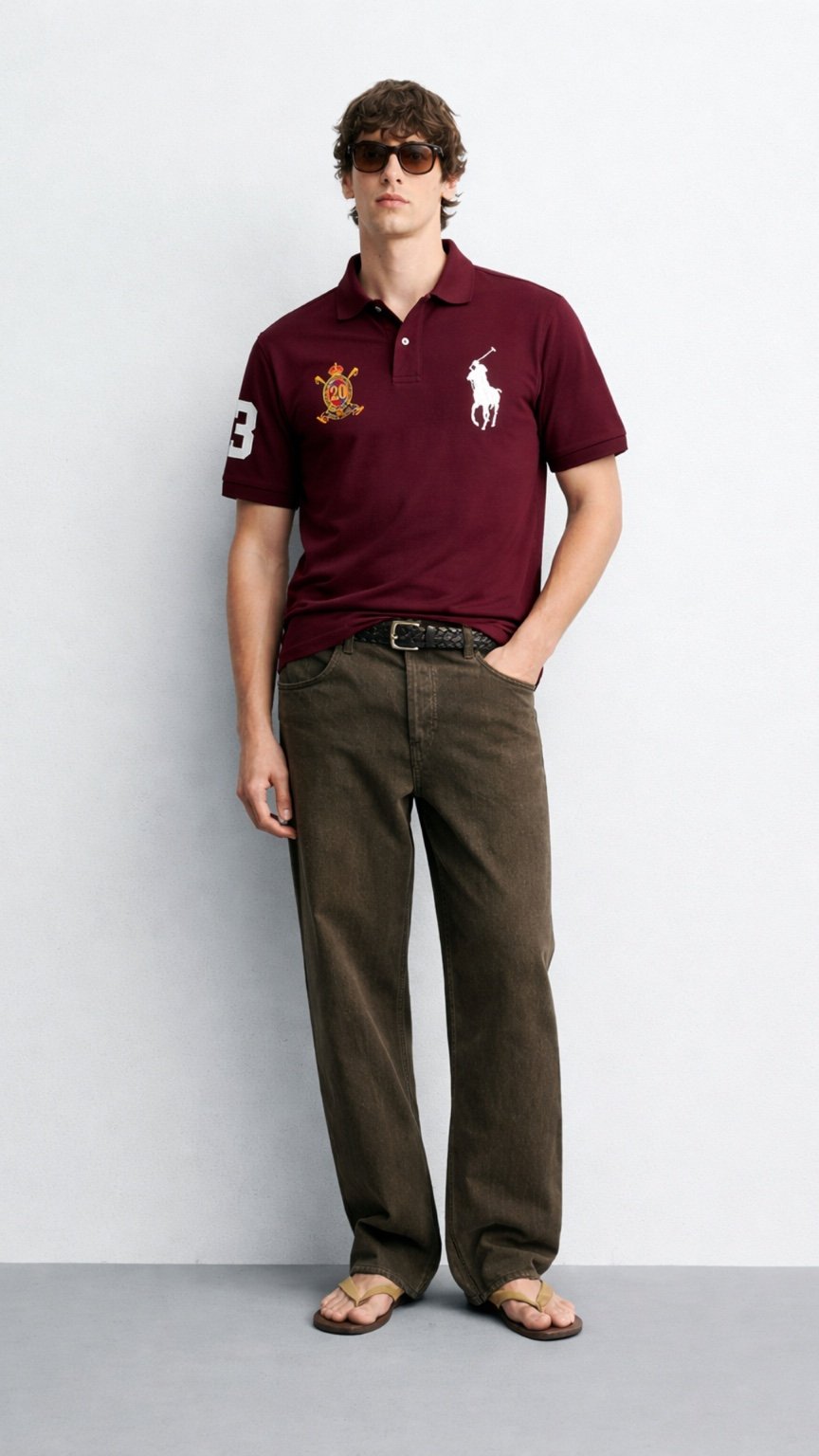 Man wearing a maroon Polo Ralph Lauren shirt and brown pants against a white background