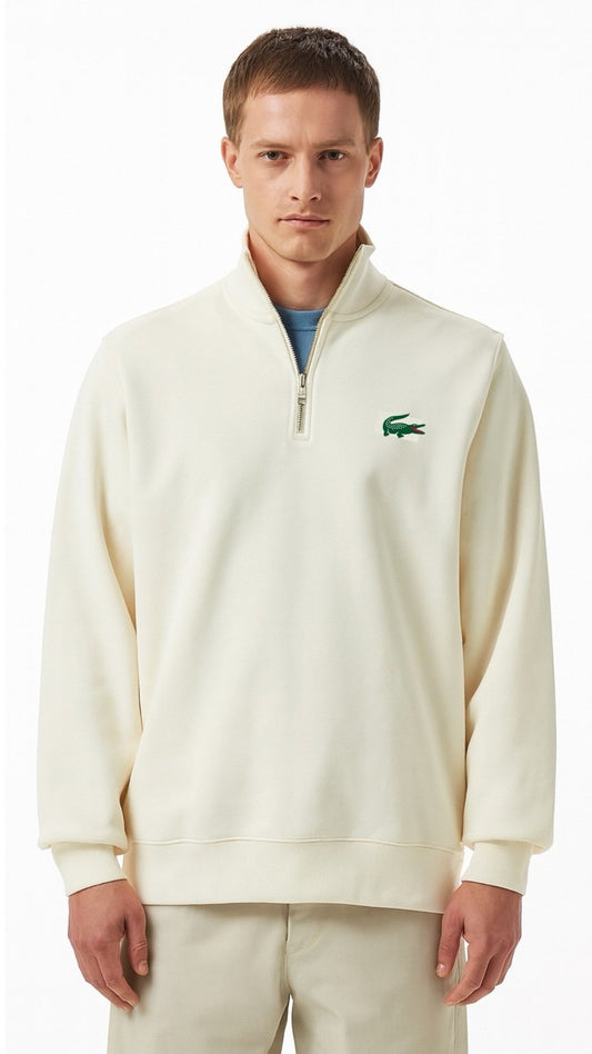Man wearing a cream-colored sweatshirt with a brand logo on a white background