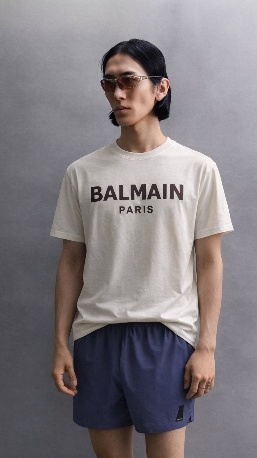 Person wearing a Balmain Paris t-shirt against a gray background