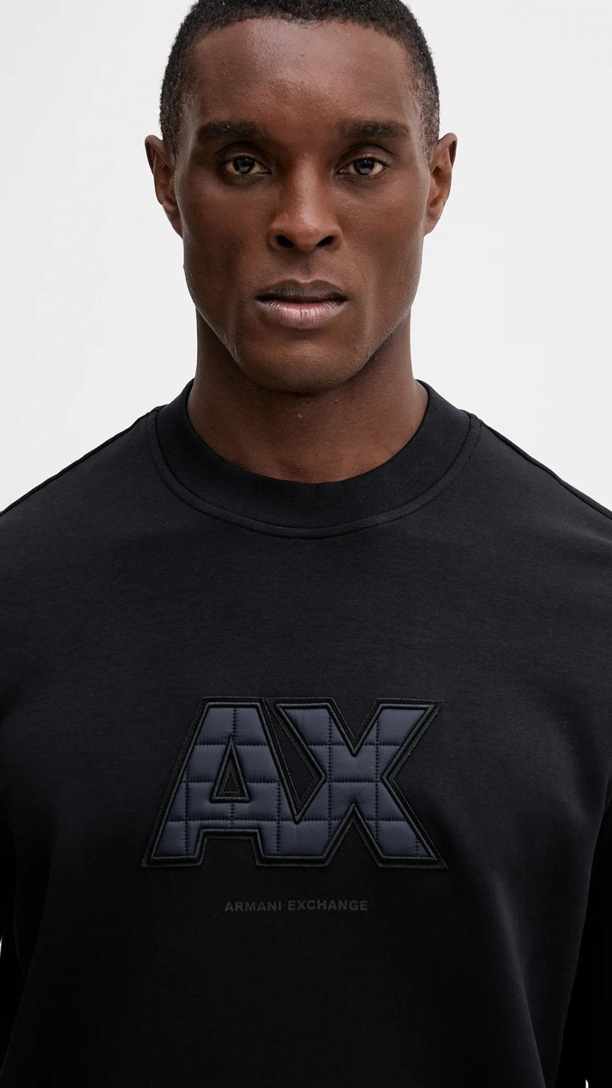 Man wearing a black Armani Exchange sweatshirt against a white background