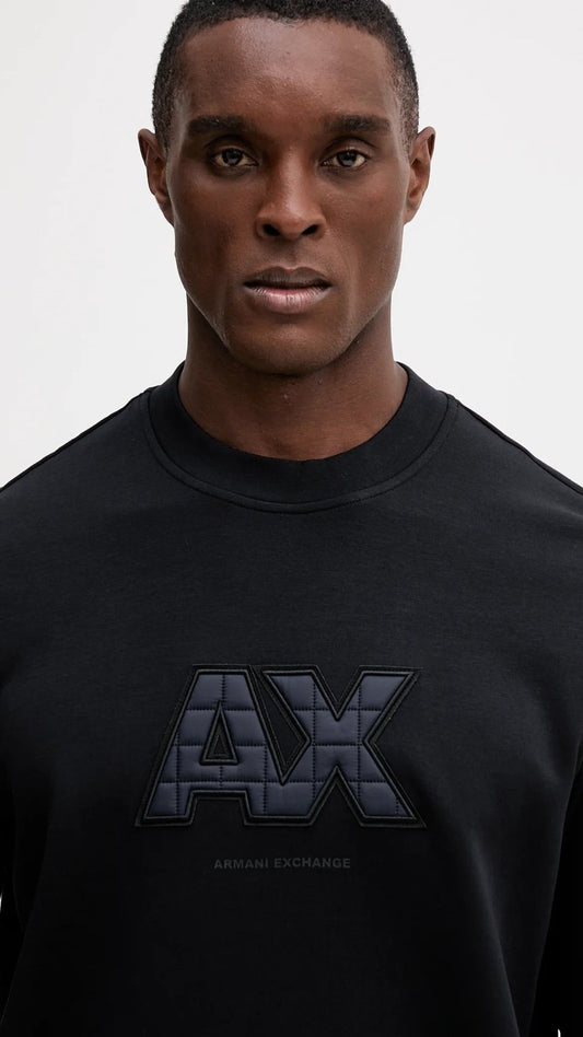Man wearing a black Armani Exchange sweatshirt against a white background