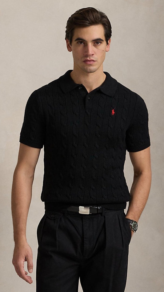 Man wearing a black polo shirt with a red logo on a beige background