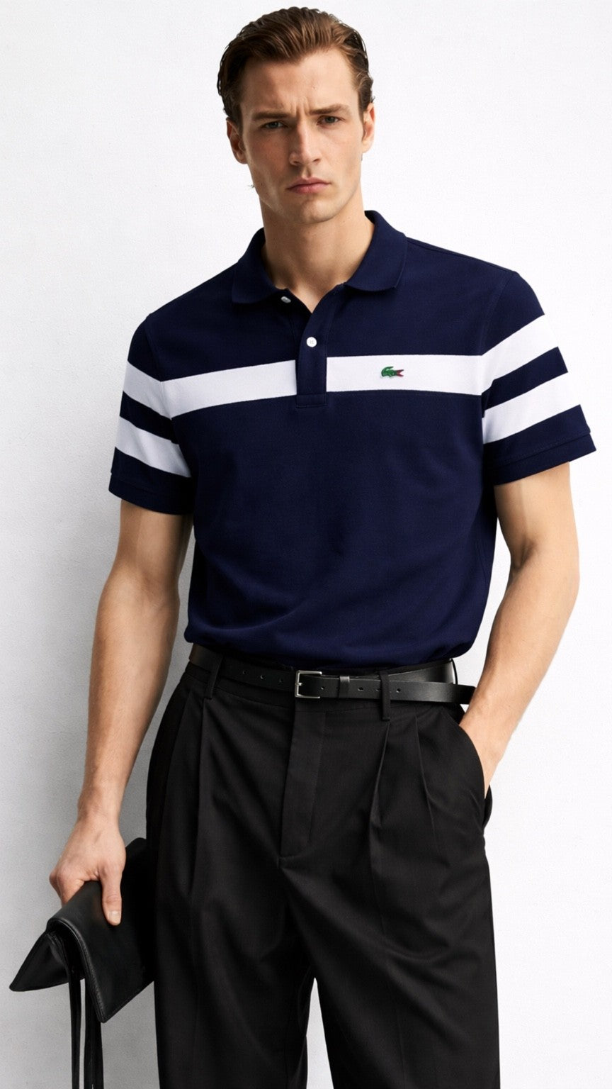 Man wearing a navy polo shirt with white stripes and black pants against a white background