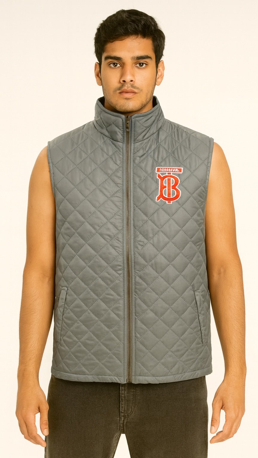 Man wearing a gray quilted vest with a logo on a beige background