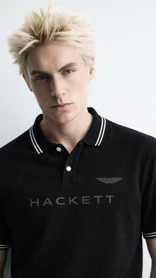 Person wearing a black Hackett polo shirt against a white background