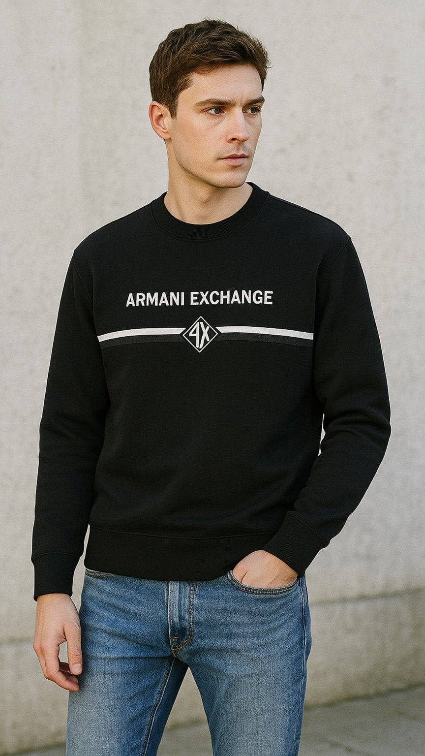 Man wearing a black Armani Exchange sweatshirt against a gray wall.