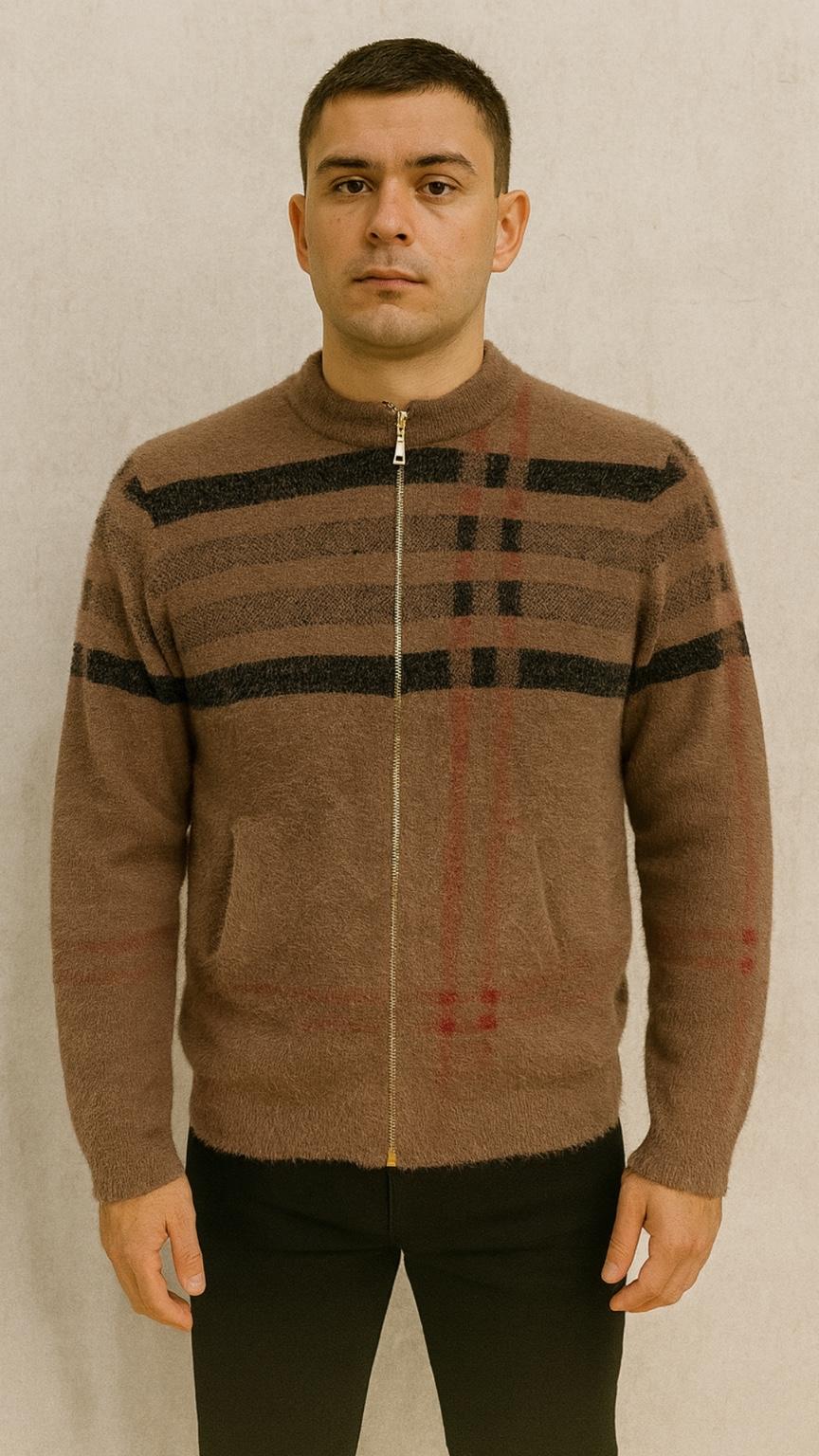 Man wearing a brown zip-up sweater with black and red patterns against a plain background