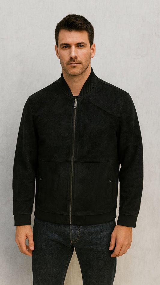 Man wearing a black jacket against a gray background