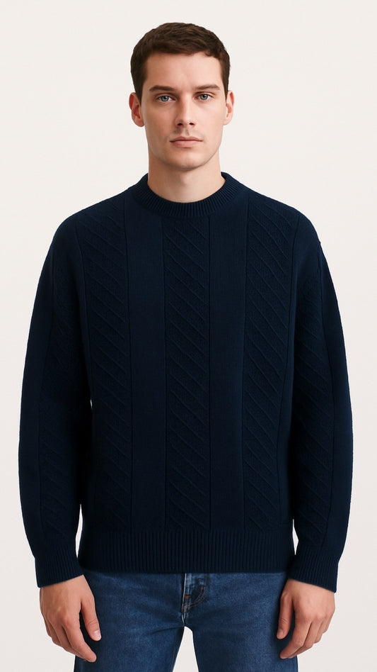 Man wearing a navy sweater and jeans on a light background