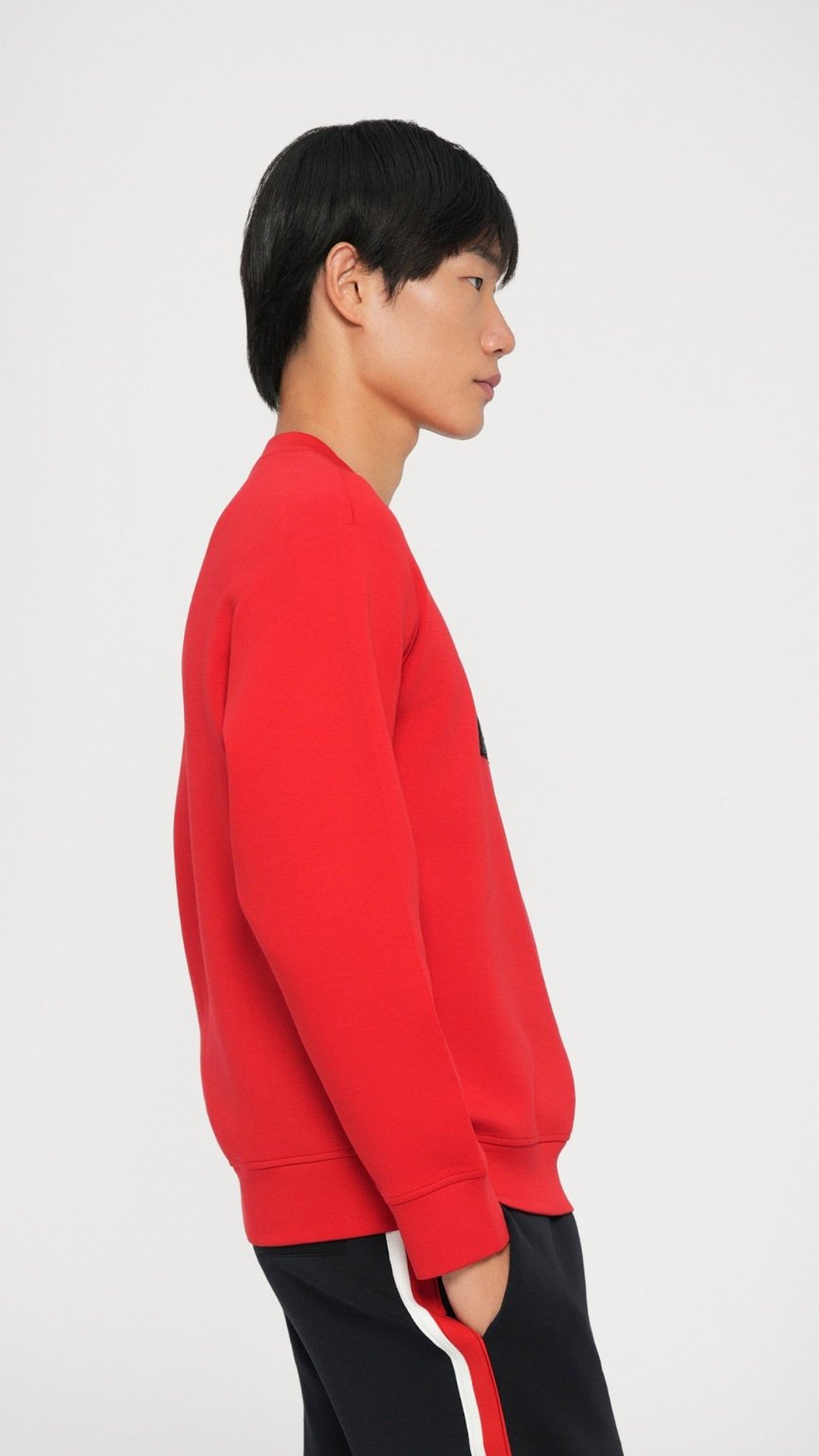 Person wearing a red sweatshirt and black pants with white stripes on a white background