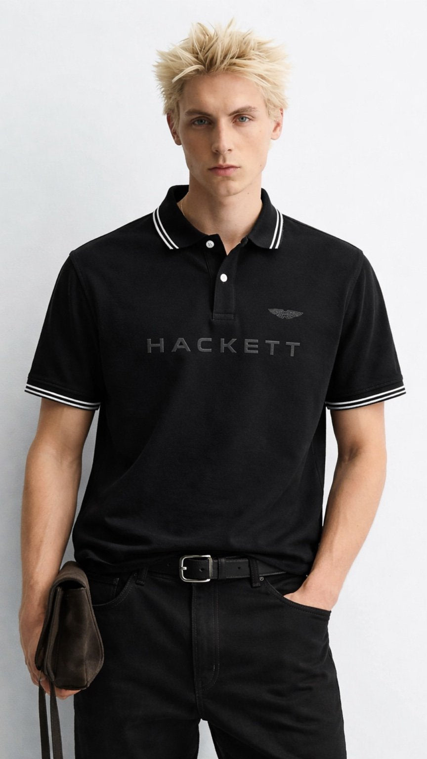 Man wearing a black Hackett polo shirt against a white background
