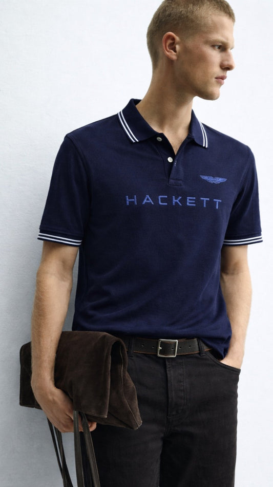 Man wearing a navy Hackett polo shirt against a white background