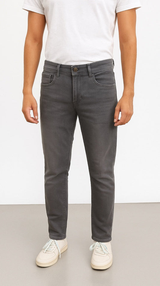 Person wearing gray jeans and a white t-shirt on a plain background