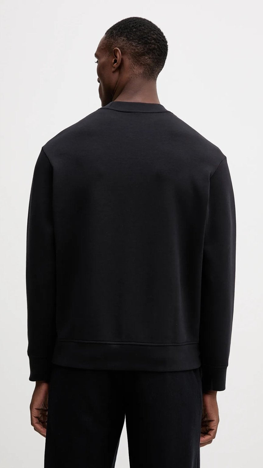 Person wearing a black sweatshirt and pants on a white background