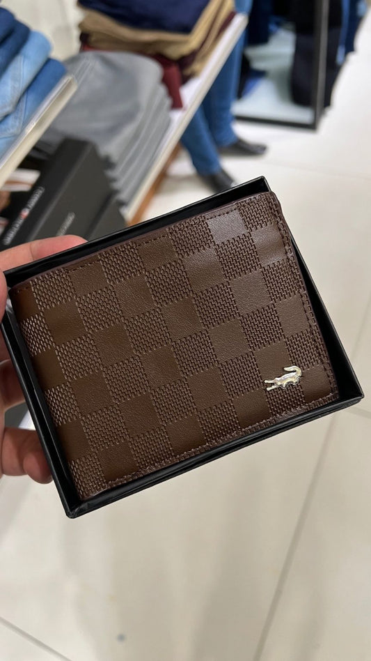 Brown wallet with a brand logo held by a hand on a light background