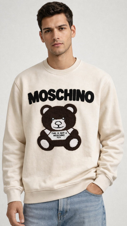 Man wearing a Moschino sweatshirt with a bear graphic on a plain background