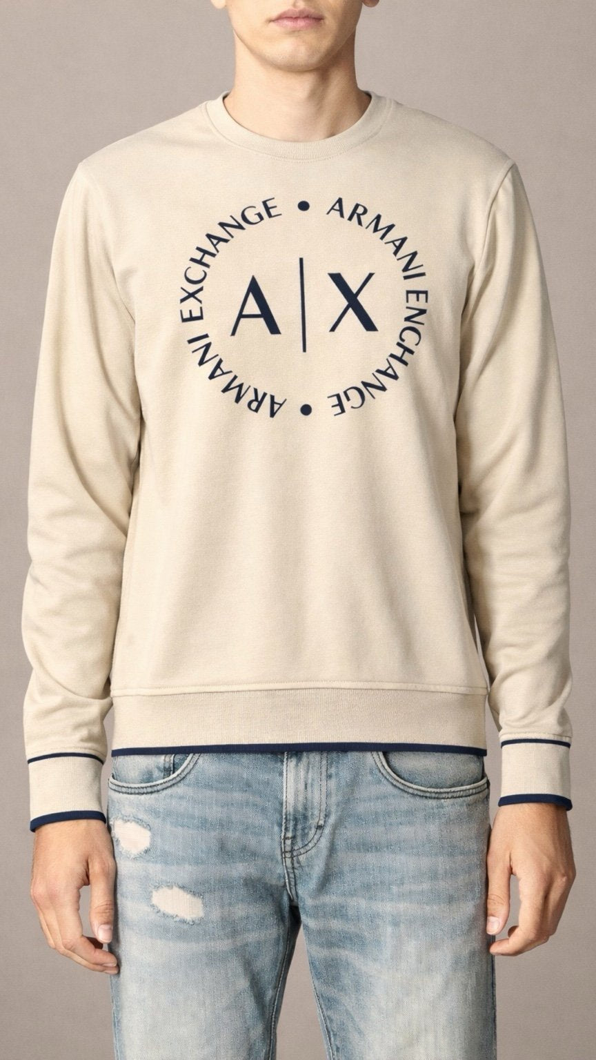Person wearing a beige Armani Exchange sweatshirt and jeans against a neutral background