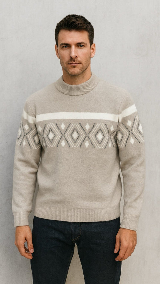 Man wearing a beige sweater with a patterned design against a plain background
