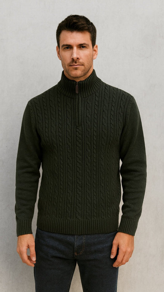 Man wearing a dark green cable knit sweater against a plain background