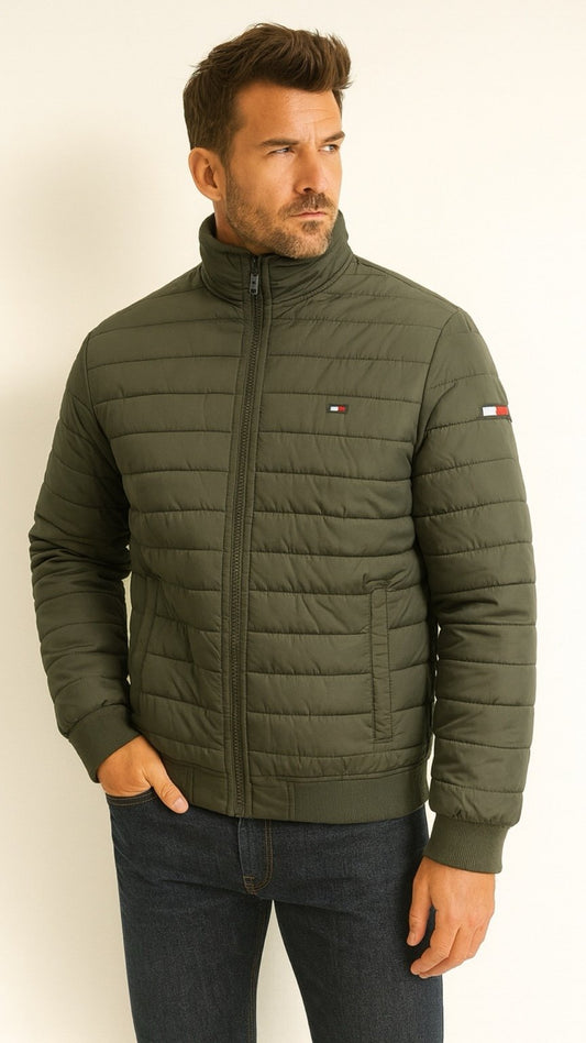 Man wearing a green quilted jacket with a visible brand logo on a white background