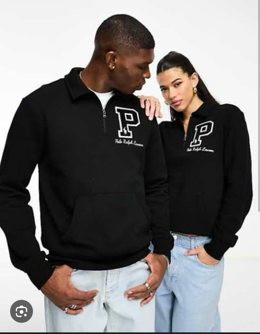 Two people wearing black polo shirts with a logo on a white background