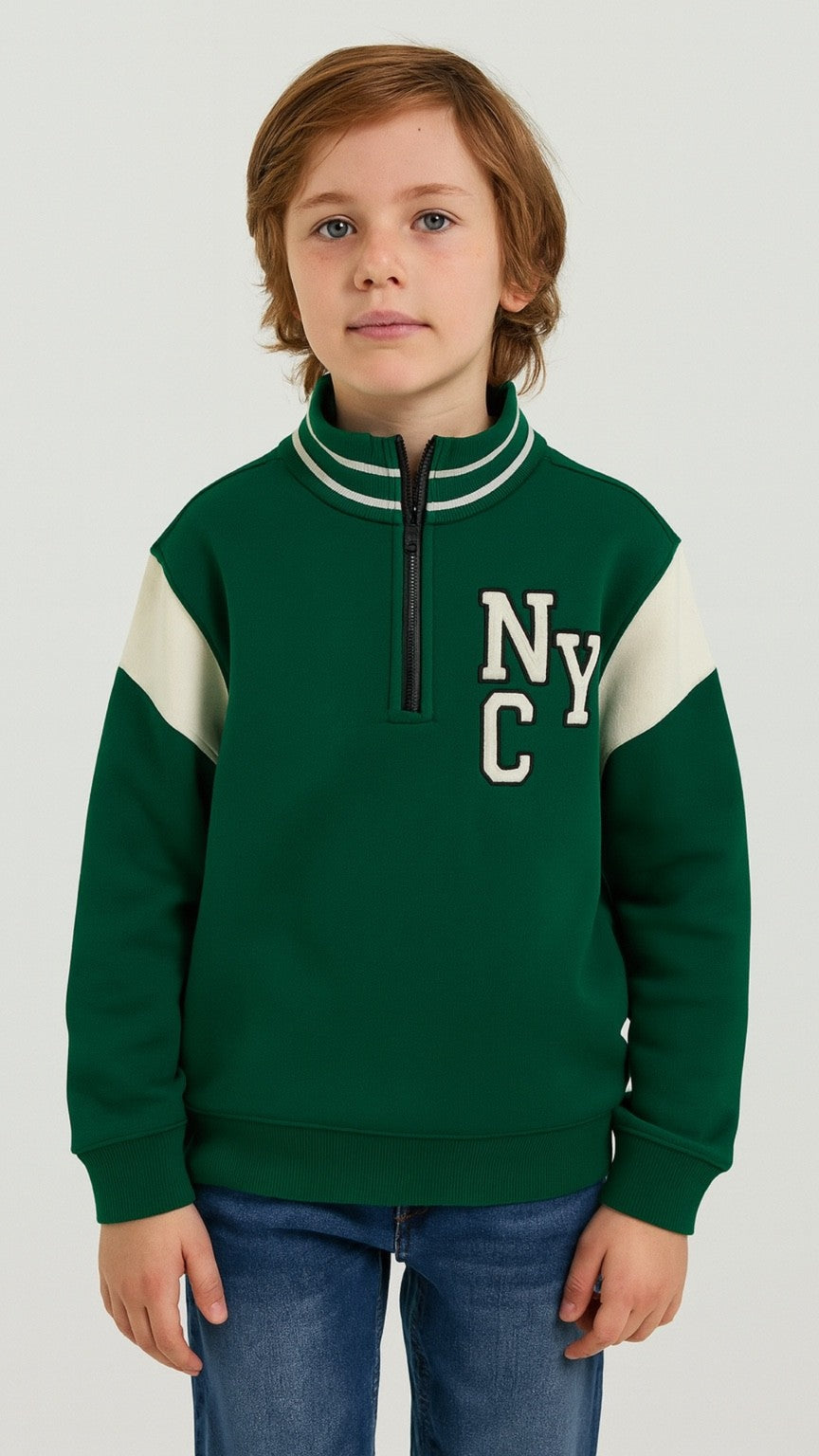 Child wearing a green and white sweatshirt with 'NYC' on a plain background
