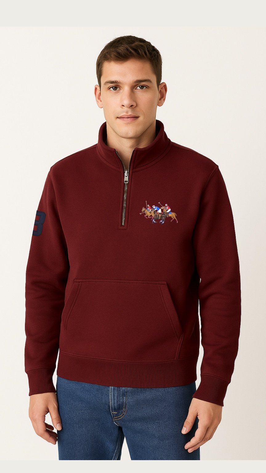 Man wearing a burgundy half-zip sweatshirt with a colorful emblem on a white background