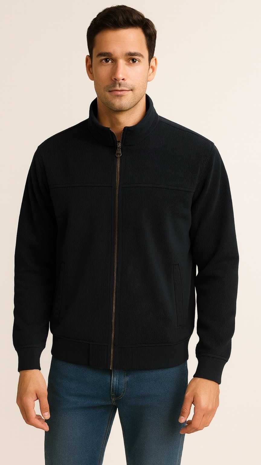 Man wearing a black jacket and blue jeans on a beige background