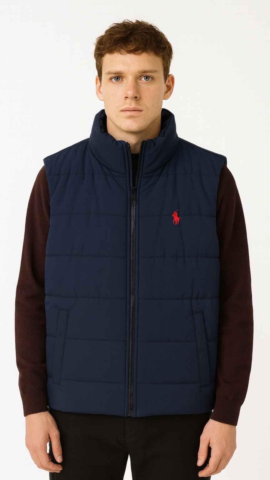 Man wearing a navy puffer vest with a red logo on a white background