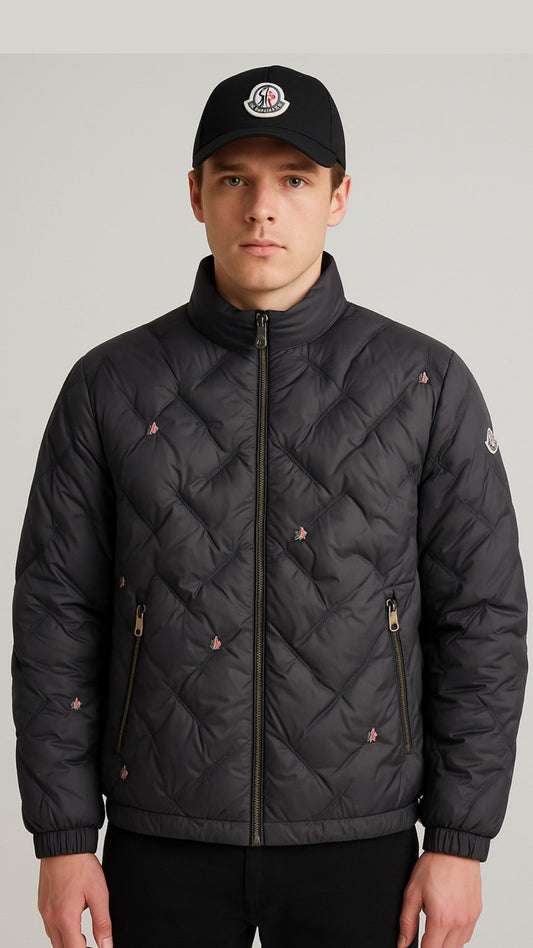 Man wearing a black quilted jacket and cap on a gray background